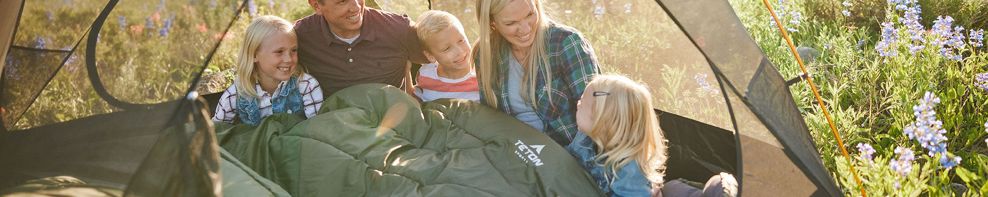 A family snuggled in their Celsius Mammoth sleeping bag.