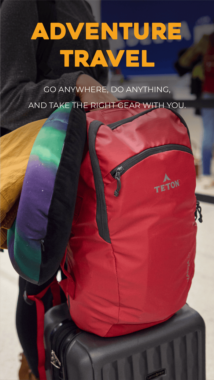 Adventure Travel Solutions Nanda 30L in Ruby Teton backpack on a suitcase with 'Adventure Travel' text and slogan.