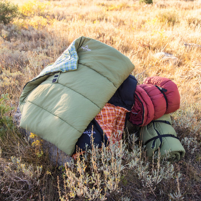 rolled green, red, black with plaid inner lining sleeping bags