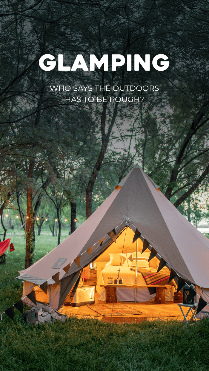 Glamping Solutions: Glamping tent with interior lights on a grassy area with trees and a dark sky.