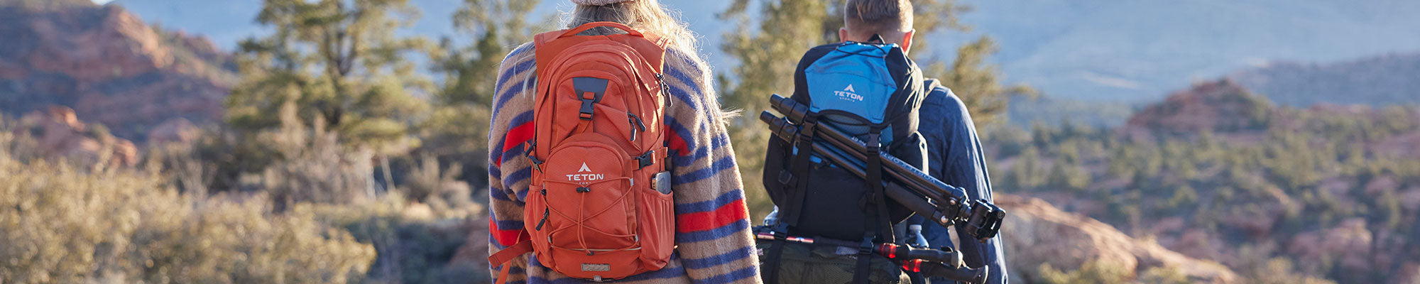 A man and a woman hiking with their TETON Sports backpacks