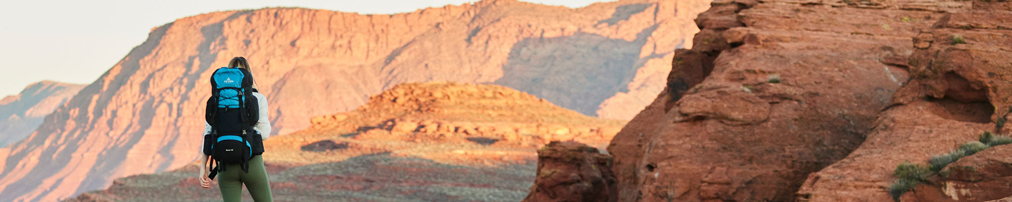 A woman with her TETON Sports Scout Backpacks looking out at the red rocks