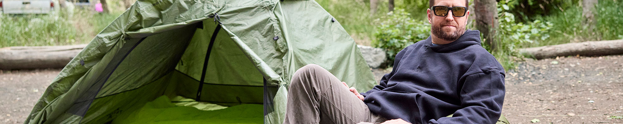 A man at a campsite wearing a Teton hoodie