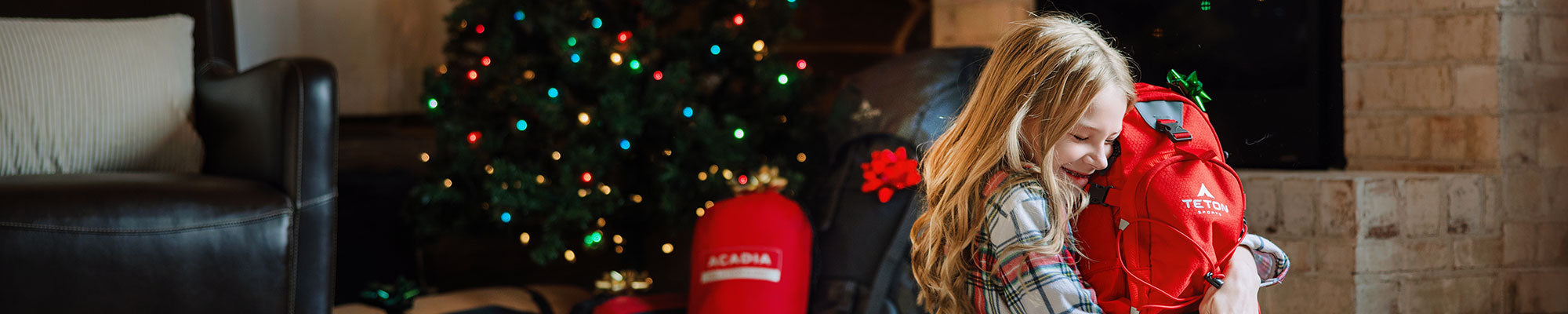 A girl hugging her Oasis hydration pack near the Christmas tree