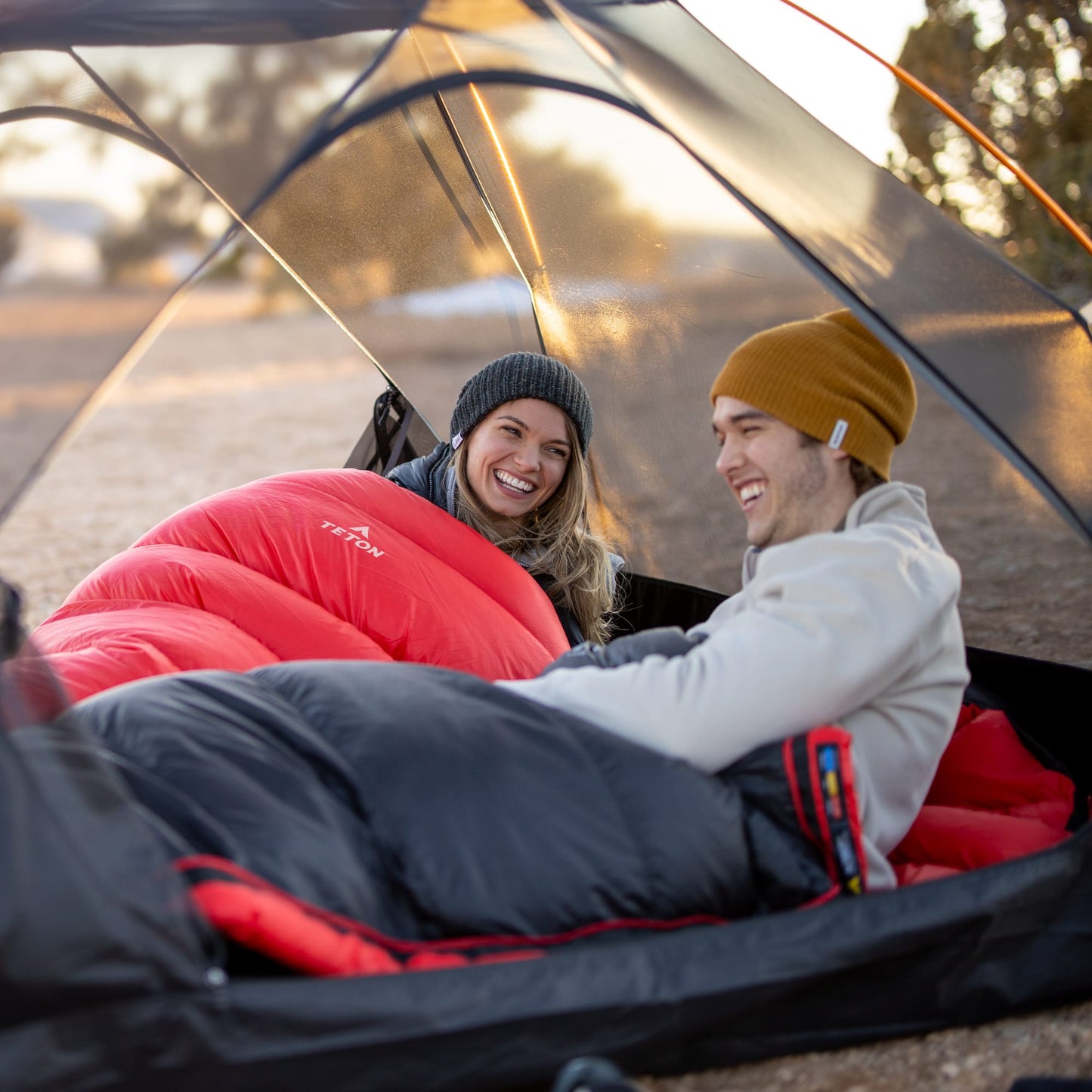 2 people in altos mummy sleeping bags in a camping setting