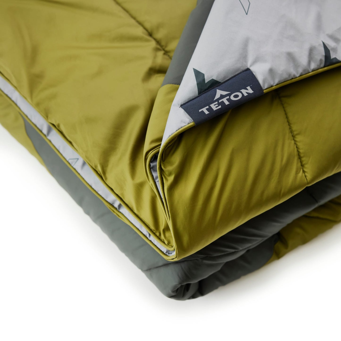 Folded green outdoor blanket with Teton brand logo on a white background