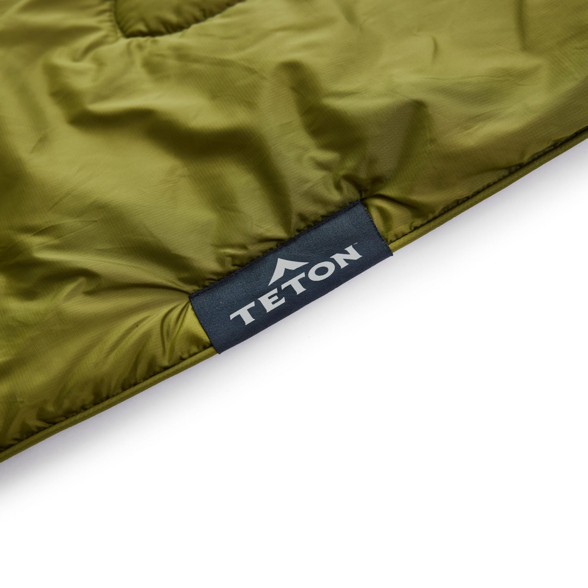 Green outdoor blanket with Teton brand label on a white background