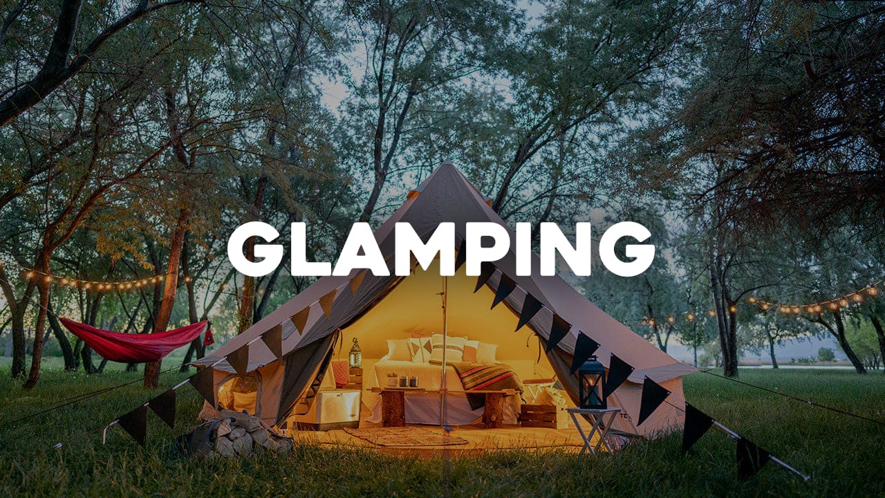 Glamping setup with a tent, hammock, and lanterns in a forest setting with "GLAMPING" text overlay