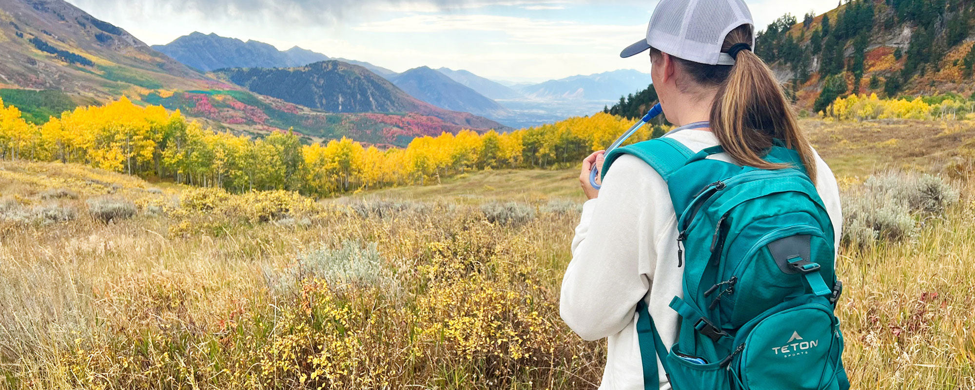 A woman on a fall hike with her Oasis pack