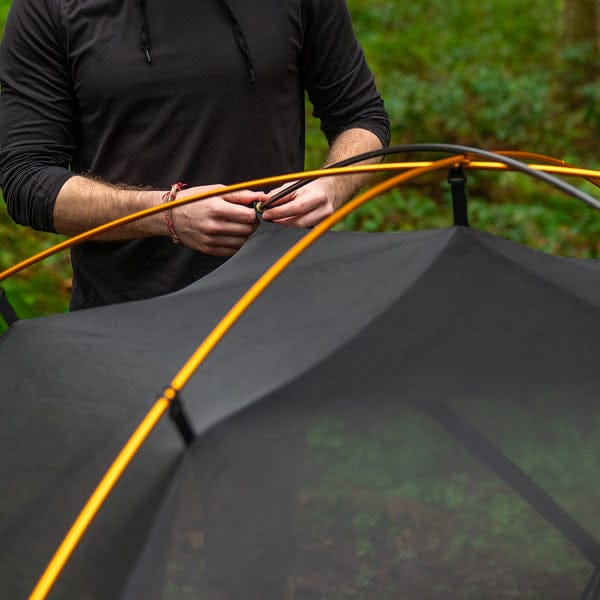 A person setting up the mountain ultra tent's lightweight poles.