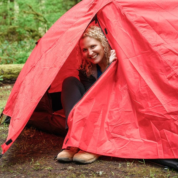 A woman seeking shelter inside the mountain ultra tent rainfly.