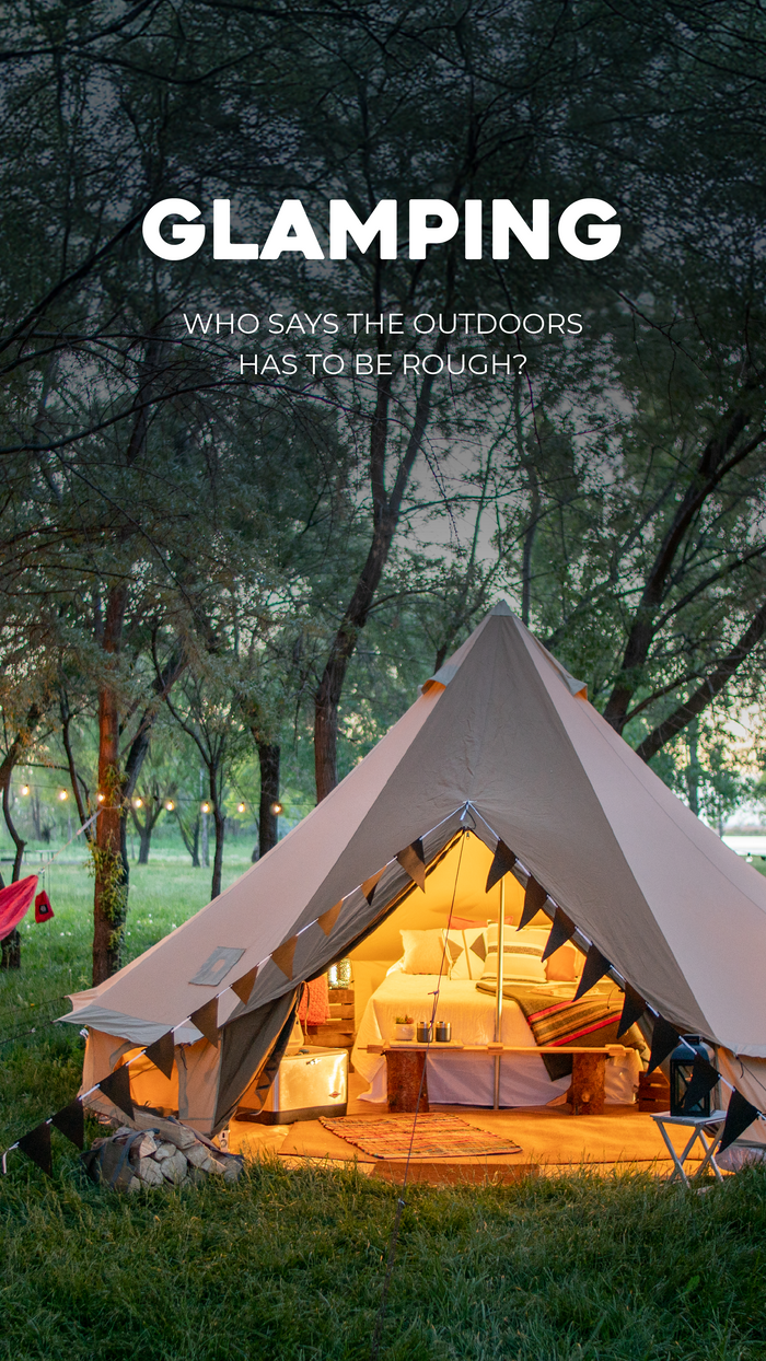 Glamping Solutions: Glamping tent with interior lights on a grassy area with trees and a dark sky.