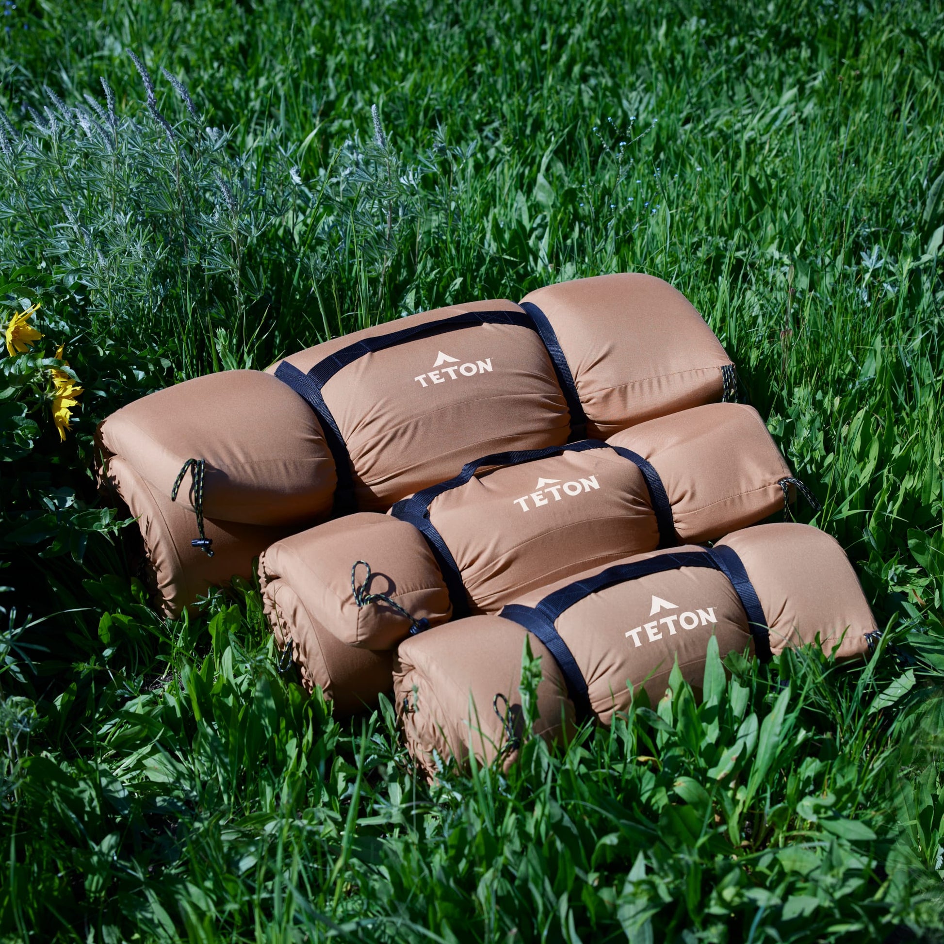 Rolled up 3 sizes of brown canvas camping pad, LARGE, XL & XXL