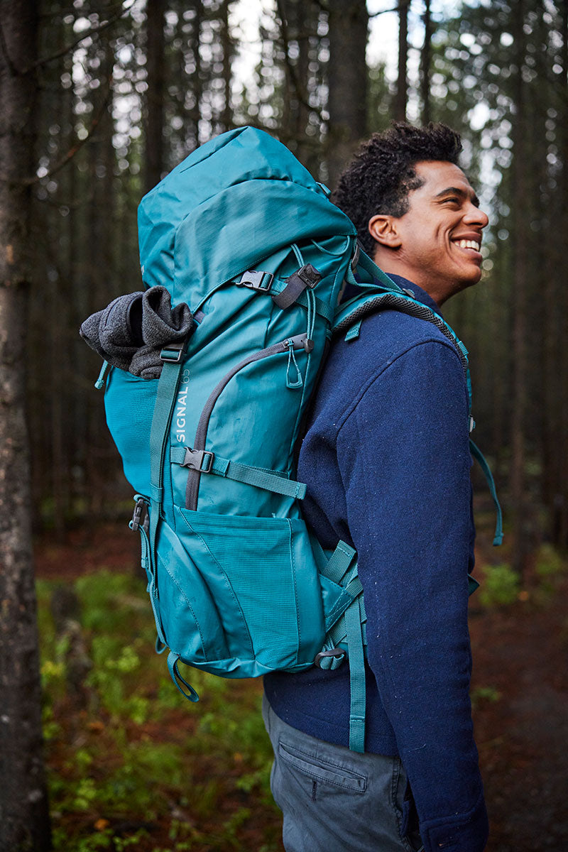 A man backpacking with his Signal backpack