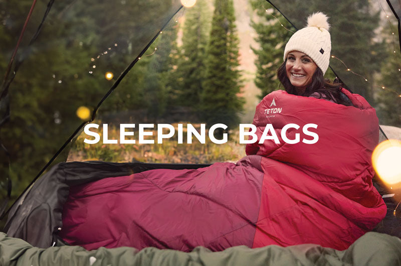 A woman snuggled up in her TETON Sports Celsius sleeping bag. 