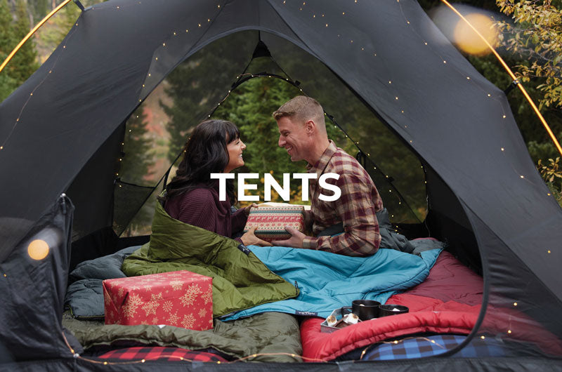 A man and a woman exchanging gifts in their TETON Sports Mountain Ultra Tent.